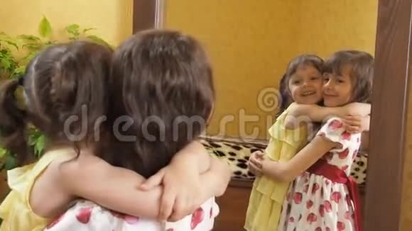 镜子前的孩子们姐妹们在拥抱镜子前的小女孩视频的预览图