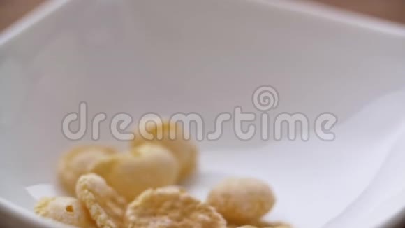 玉米片缓慢地落在白色的碗里近景视频的预览图