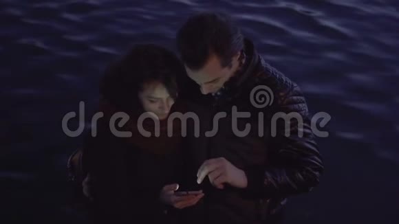 年轻夫妇带着智能手机在户外视频的预览图