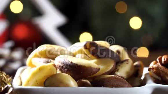 核桃仁巴西坚果和杏仁在一个碗里的乡村老木桌与圣诞节背景一张幻灯片视频的预览图
