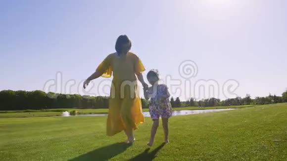 妈妈和女儿一起在草地上奔跑视频的预览图