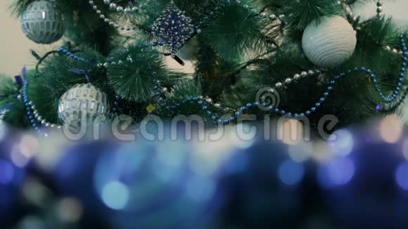 用蓝灯装饰的圣诞树白色圣诞球和花环前景中的非聚焦图像视频的预览图