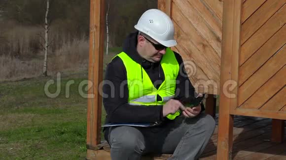 土木工程师在建筑物的木质结构上使用平板电脑视频的预览图