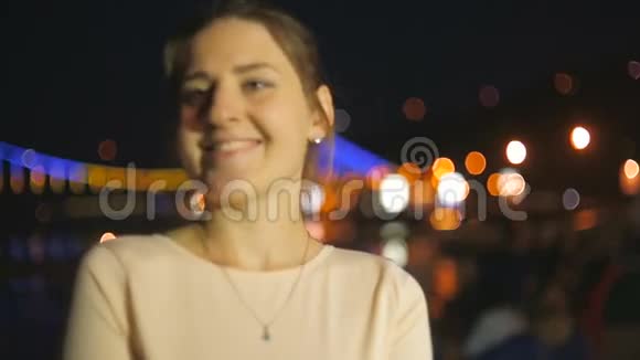 晚上站在海边的一位美丽的年轻女子视频的预览图
