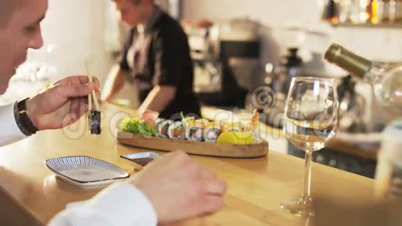 男人吃寿司卷服务员倒酒视频的预览图