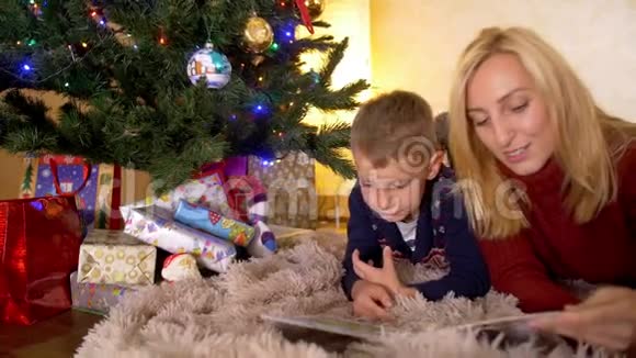妈妈和儿子在新年树下看书视频的预览图