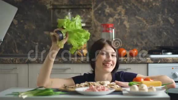 美丽的微笑的女人做饭在厨房里玩蔬菜视频的预览图