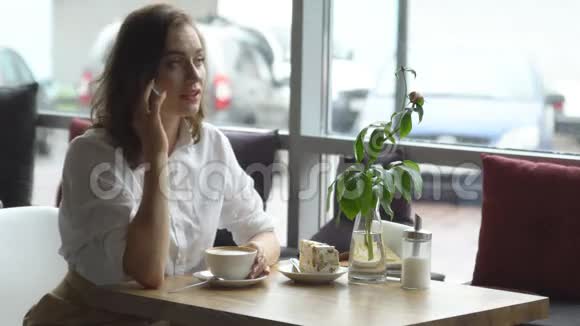小女孩在咖啡馆里喝咖啡用手机说话商务女性午休时间视频的预览图