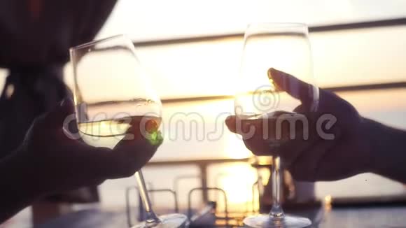 两个人手拿酒杯手拿酒背景是夕阳和大海高清1920x1080慢动作视频的预览图