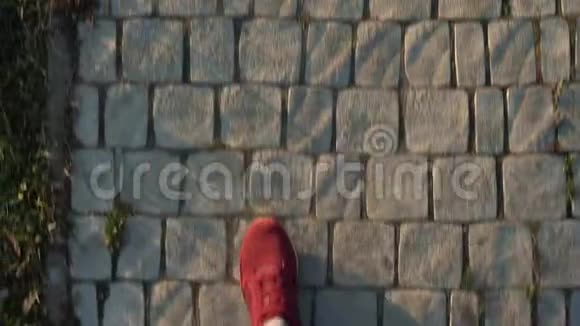 穿着红色运动鞋的男士双腿在人行道上的俯视图视频的预览图