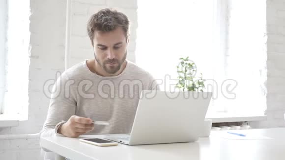 手提电脑男子凭借记卡在线支付视频的预览图