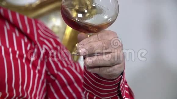 一只雄性手拿着一杯红酒转身的细节视频的预览图