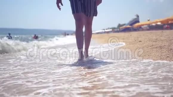 一个人走在沙滩上海浪拍打着他的脚高清1920x1080慢动作视频的预览图