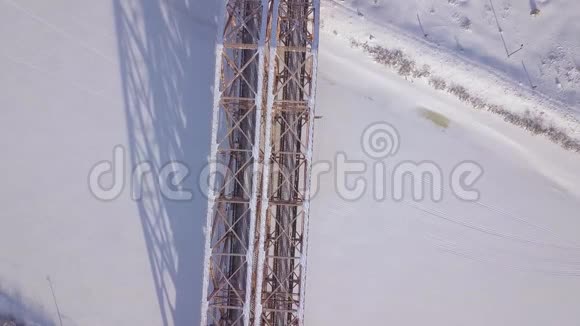铁路桥梁供火车在冰冻的河流上移动冬季景观无人机视野空中观景吊火车桥视频的预览图
