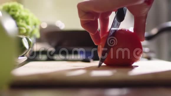 一个女人正在厨房里做沙拉她把红色多汁的番茄切成三部分视频的预览图