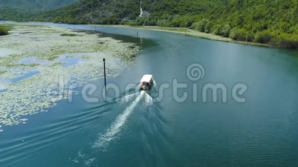 摩托艇漂浮在由睡莲构成的Crnojevica河上视频的预览图