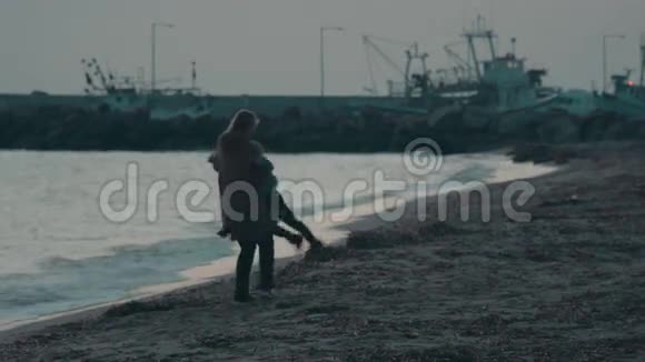 寒冷的一天妈妈和孩子在海滩上玩得很开心视频的预览图