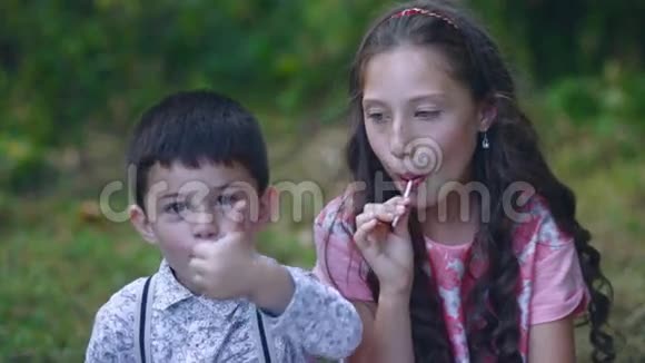 漂亮的小朋友在花园里吃棒棒糖视频的预览图
