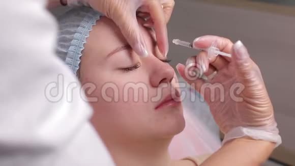 医生在中年妇女前额眉间注射面部提升注射以消除面部皱纹视频的预览图