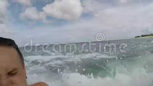 快乐的夫妻在海洋中挥手游泳蜜月在大浪中玩得很开心巴厘热带岛屿视频的预览图