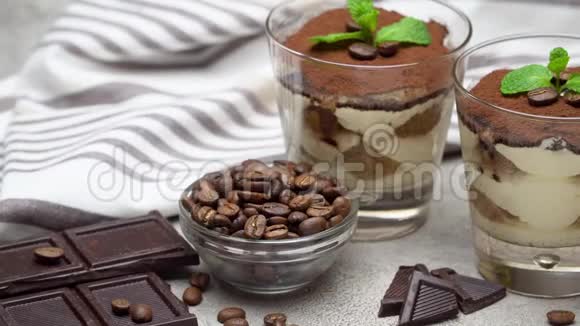 经典的提拉米苏甜点放在玻璃杯和混凝土背景的巧克力棒上视频的预览图