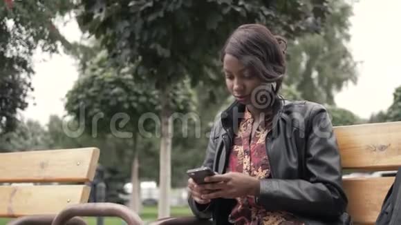英俊时髦的非裔美国黑人女性在手机上录制语音信息他正在城市户外握着视频的预览图