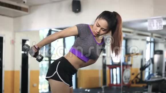 亚洲女人在健身房用哑铃锻炼视频的预览图