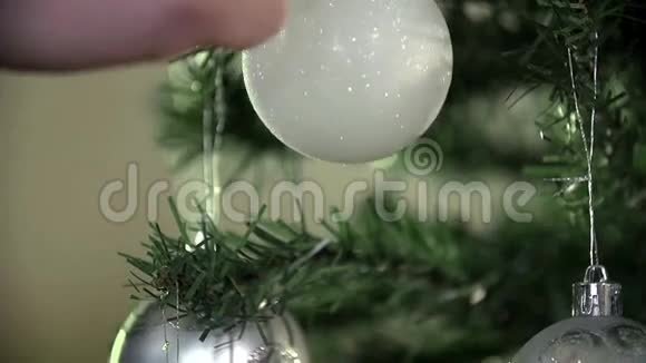 白色装饰物缓缓地挂在圣诞树上视频的预览图