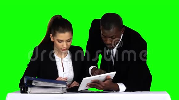 两个商人讨论笔记本电脑上的文件绿色屏幕视频的预览图