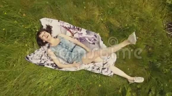上景美丽的年轻女子夏日在草地上放松视频的预览图