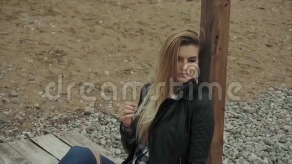 年轻的金发女人坐在木墩上休息视频的预览图