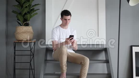 男人用手机坐在楼梯上视频的预览图