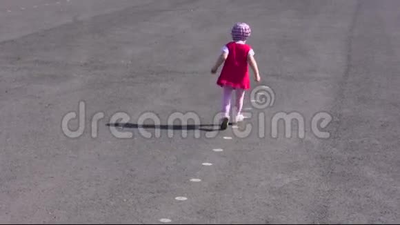 小女孩在柏油路上跑步视频的预览图