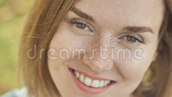 一个满脸雀斑的微笑少女的面部特写视频的预览图
