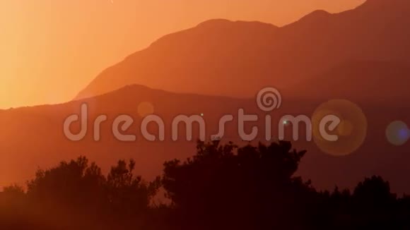 温暖的夏日山全景日落与片片阳光在相机的镜头视频的预览图