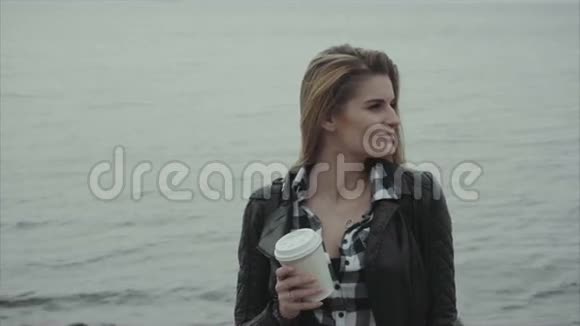 有魅力的金发女郎在海边喝杯咖啡的肖像视频的预览图