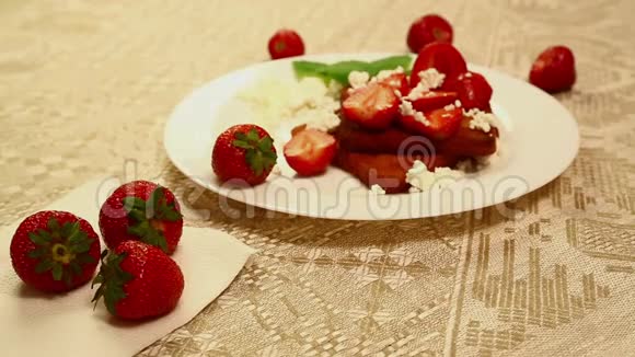 在一张白色盘子里的桌子上放着一小罐干酪和草莓的烤面包视频的预览图