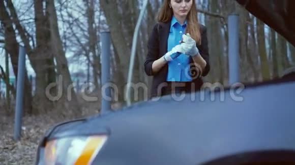 戴着手套的漂亮女孩在4K内检查车里的油量视频的预览图