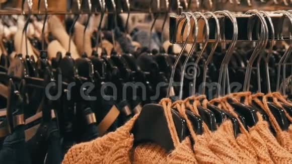 时尚的暖衣收藏挂在衣架上的各种颜色的新型温暖时尚毛衣数量众多视频的预览图