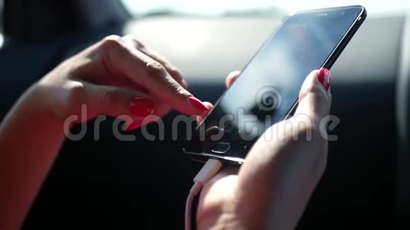 手机在一个女人手中的车里女孩点击屏幕高清1920x1080慢动作视频的预览图