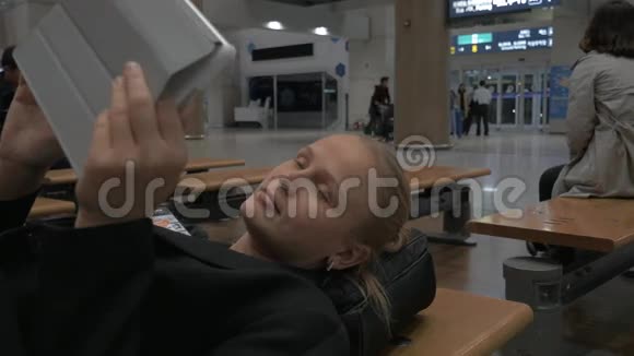 坐在机场候机楼长凳上的女人视频的预览图
