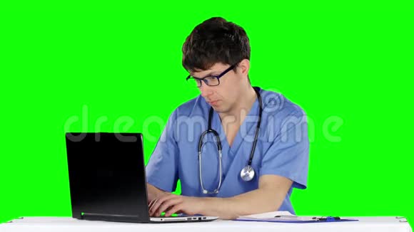 友好快乐的男医生在办公室使用笔记本电脑绿色屏幕视频的预览图