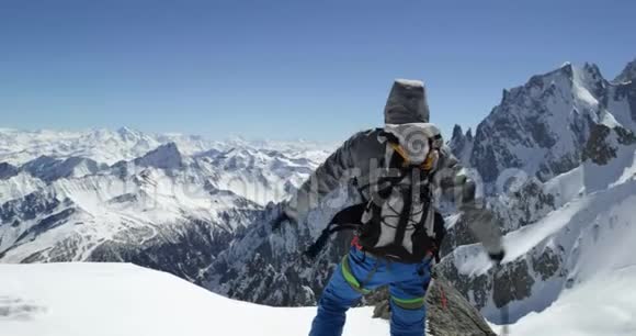 登山者在阳光明媚的一天到达雪山顶峰登山滑雪活动冬季滑雪者视频的预览图