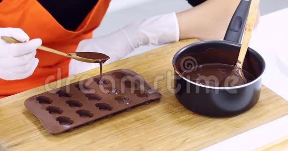有人把巧克力倒进巧克力模子里视频的预览图