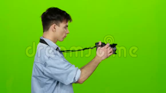 人在专业摄像机上拍摄景观绿色屏幕视频的预览图