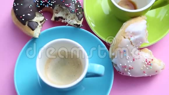 旋转粉红色盘子有两杯咖啡和甜甜圈视频的预览图