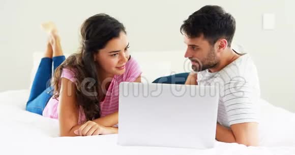 两人在床上使用笔记本电脑时相互交流视频的预览图