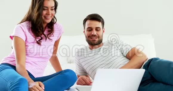 两人在床上使用笔记本电脑时相互交流视频的预览图