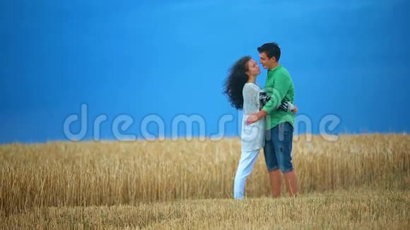 年轻夫妇在田野里接吻年轻女子在麦田里拥抱一个白种人亲吻每一个人视频的预览图