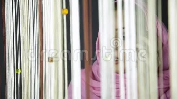 年轻的阿拉伯穆斯林妇女戴着粉红色头巾在手机上说话望着窗外视频的预览图